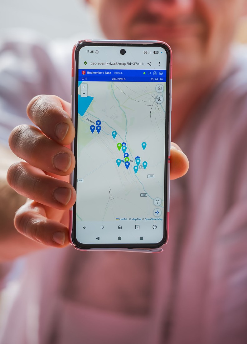 Hráč drží telefón s mapou stanovíšť počas Dňa obce v Budmericiach